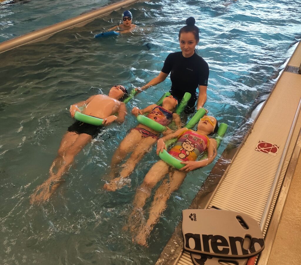 Instruktorka pływania ucząca dzieci pływać